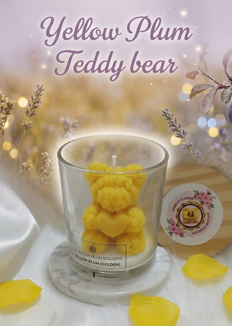 Yellow teddy bear candle in a glass holder with decorative elements on a soft background