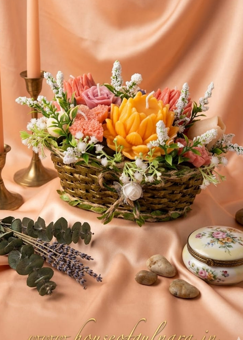 Decorative CANDLE floral arrangement in a HANDMADE CANE basket with candles and stones on a peach fabric background.