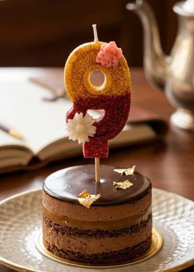 Small chocolate cake with a number 9 candle on a plate, set against a warm-toned background.