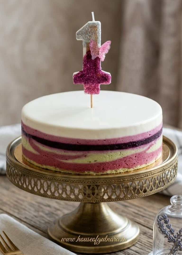 Small birthday cake with a number one candle on a rustic wooden table.