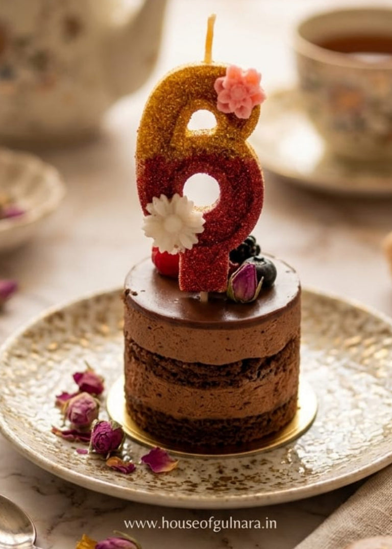 Small cake with a number 6 candle on a plate with tea and cookies.