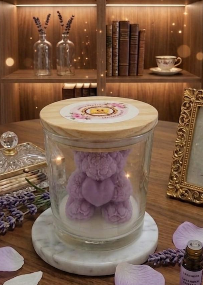 Glass jar with a wooden lid containing a purple teddy bear on a wooden surface with books and decor in the background.