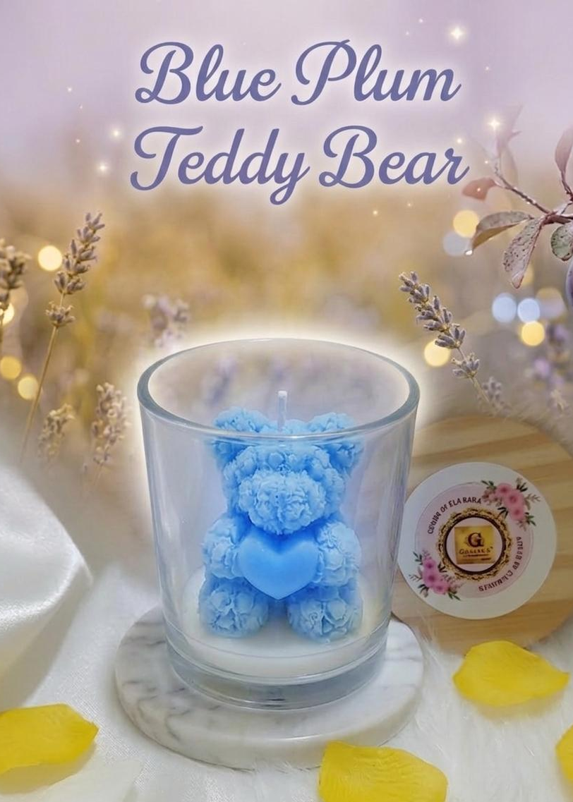 Blue teddy bear candle in a glass holder with decorative elements on a soft focus background
