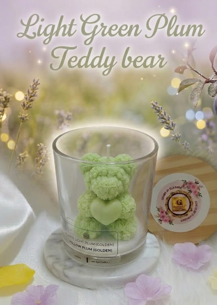 Light green teddy bear in a glass container with floral decorations on a soft background