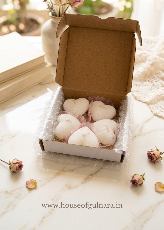 Box of heart-shaped items on a marble surface with decorative flowers in the background