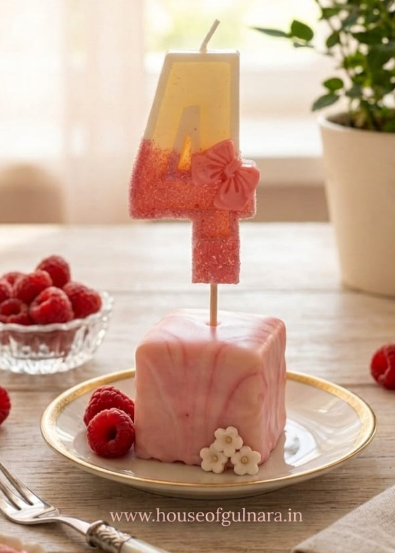 Pink number 4 cake topper on a cake with raspberries and a fork on a wooden table.