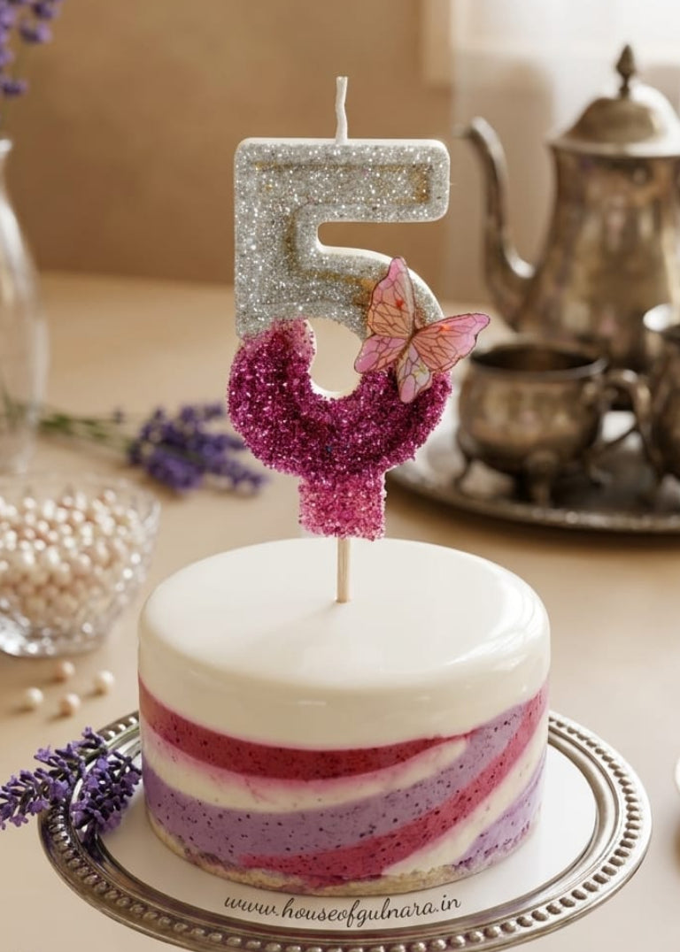 Small cake with a number 5 candle on a decorative stand with lavender flowers.
