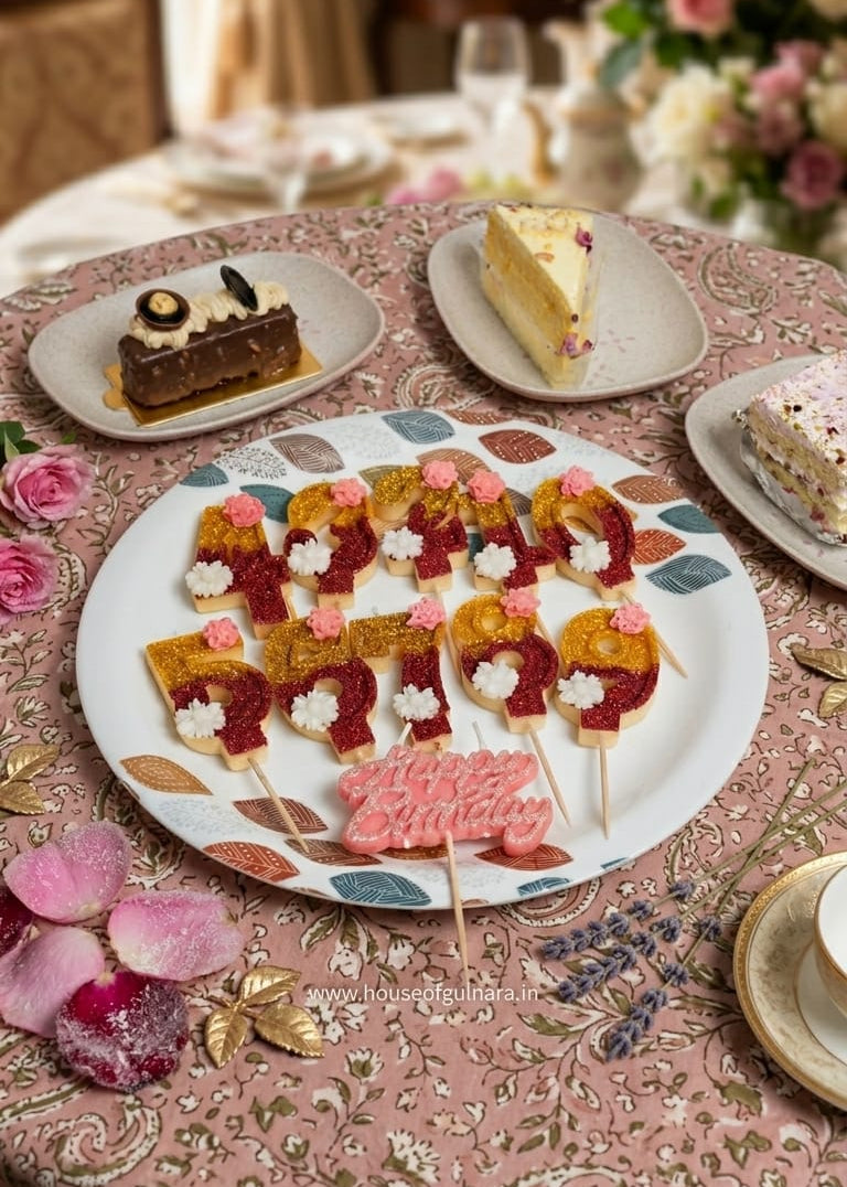 Decorative plate with cake pops on a table with floral arrangements