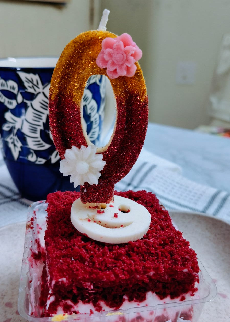 zero number candle on a Red velvet cake with a decorative candle on a white plate
