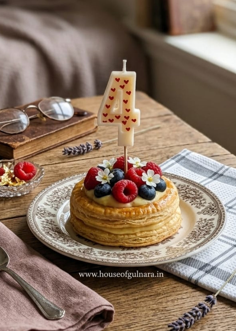 Small cake with berries on a wooden table with books and glasses in the background